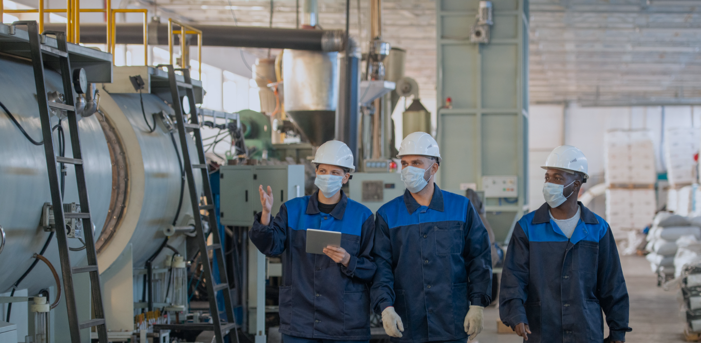 industrial-technologist-formalwear-using-tablet-while-discussing-technical-sketch-with-colleagues-workshop 1